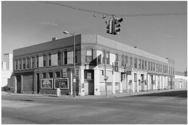 View of a commercial building at 23rd (Twenty Third) and Larimer Street in the Five Points Neighborhood of Denver, Colorado. The two story brick building has arched windows, a corner entry, and boarded-up storefronts. Sign reads: "Tenampa Club - Coors Beer."