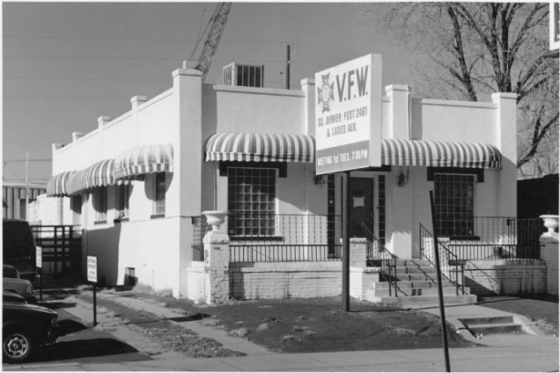 View of a V.F.W. Post at 1545 South Broadway Street in the Overland Neighborhood of Denver, Colorado. The stucco finish building has glass block windows, awnings, urns, steps, and a sign: "V.F.W. So. Denver Post 2461 & Ladies Aux."