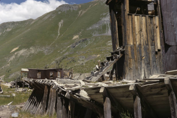 View of a wooden water flume, abandoned mine buildings and mine tailings, in the Savage Basin glacial cirque, at the Tomboy Mine in Tomboy (San Miguel County), Colorado.