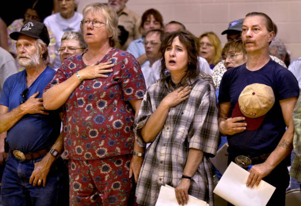 Residents say the pledge of allegiance at a community briefing.