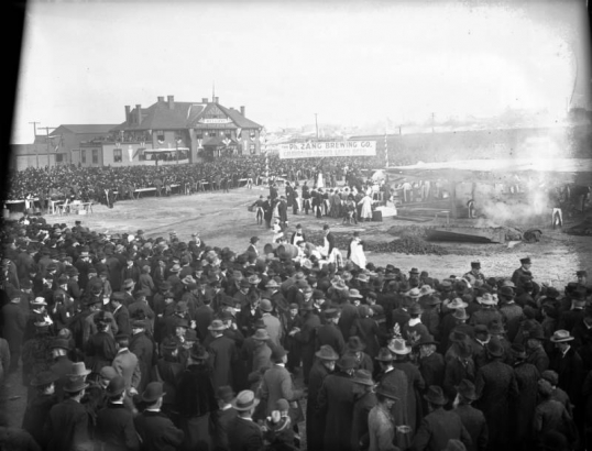A huge crowd of people surround several people cooking