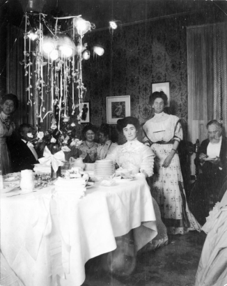 Denver Public Library (La Veta Place) staff sit inside at a table at a wedding in Denver, Colorado; Irene Smith stands.