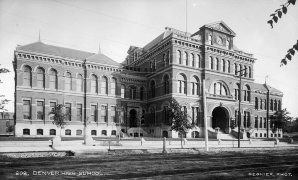 View of East Denver High School at 19th (Nineteenth) and Stout Streets in downtown Denver, Colorado; the Beaux Arts structure features mansard roof, pediments, bracketed cornices, arched windows and entry.