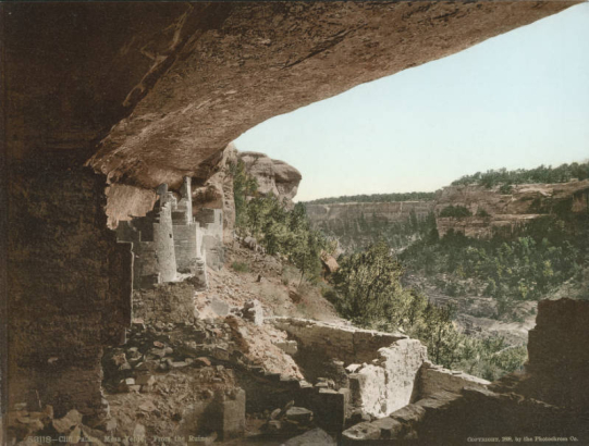 View of North American Indian (Ancestral Puebloan) dwellings in Cliff Palace at Mesa Verde National Park in Colorado. Shows masonry and mud square and round ruins under a cliff overhang on Chapin Mesa. Cliff Canyon is in the distance.