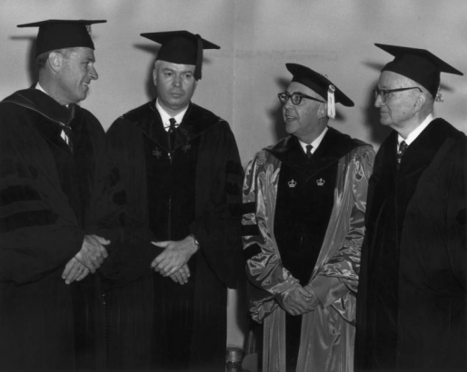 Men pose in graduation gowns and mortarboards with tassels at the  University of Colorado at Boulder.
