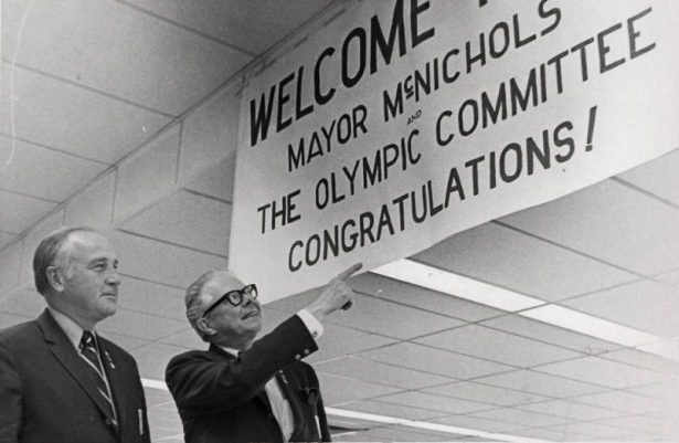 Robert J. Pringle, president of Denver's Olympic Committee, left, and Mayor McNichols were greeted on their arrival in Denver Saturday night by a large sign at Stapleton International Airport. They remained in Amsterdam a day longer than the rest of the delegation that successfully bid for the 1976 Winter Olympics earlier in the week.