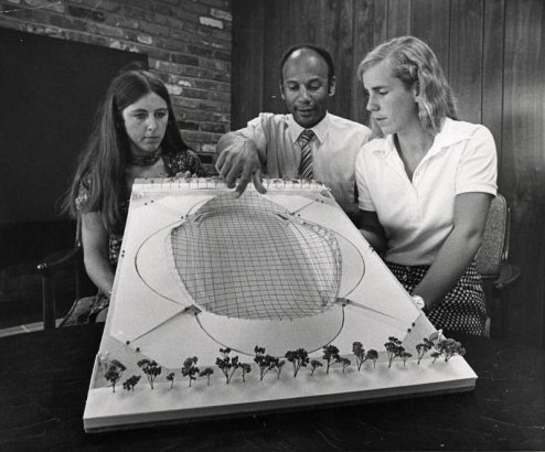 Olympic speed skating gold medalists Dianne Holum, left, and Anne Henning, right, discuss Denver's concept for an Olympic speed skating arena with David Lucy, DOC manager of support facilities. Miss Holm won a gold and a silver medal and Miss Henning a gold and bronze medal at Sapporo. The Northbrook, Ill., girls received citations from the General Federation of Women's Clubs here recently.