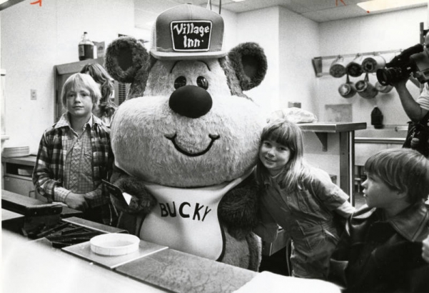 Bucky Bear, mascot of Village Inn Pancake House, opened a fund-raising campaign for the Wallace Village for Children This week by flipping flapjacks with the kids.