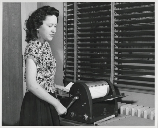 Photograph of Charles Boettcher School student June Goodrich, age 18, working at a mimeograph at the Charles Boettcher School in Denver, Colorado.