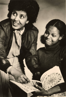 Sara Takale (left), 26, shows her fellow country woman of Ethiopia, Nigest Abrehem (right) some sentences from an English book. Sara met Nigest in a Sudanese refuge camp and is helping her adjust to the American culture.