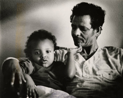 Millete Brehane Meskele, 2, relaxes with her father, Brehane Meskele Madhaiy in their new home. They immigrated from Ethiopia. 