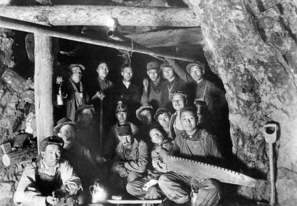 Dr. James Underhill poses with Chinese-American miners (probably) in the Colorado School of Mines' Edgar Experimental Mine near Idaho Springs (Clear Creek County), Colorado. One man holds a saw.