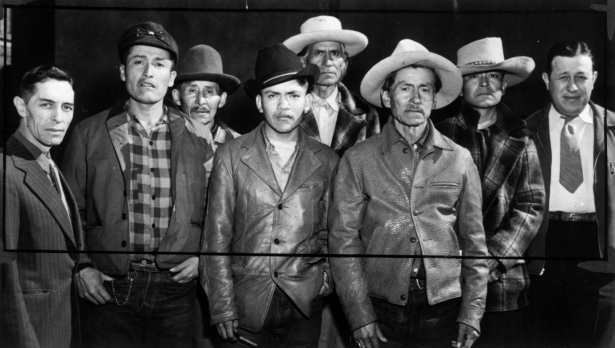 Studio portrait of Native American (Navajo) men probably in Colorado. They wear hats and jackets. One man wears a tie.