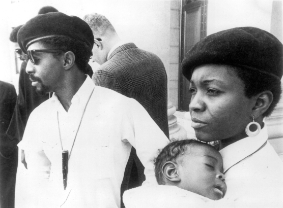 Mr. and Mrs. Joseph Sullivan, African Americans and members of the Black Panther Party, pose in Denver, Colorado. They wear berets and hold a baby.