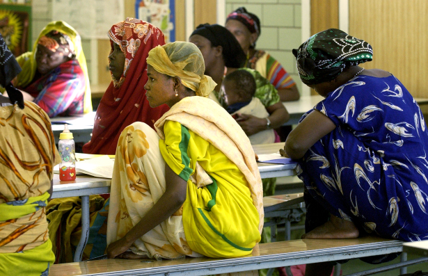 In the cafeteria of Whiteman Elementary school Somali Bantu refugee women gather wearing their traditional dress to learn English in a special class.  