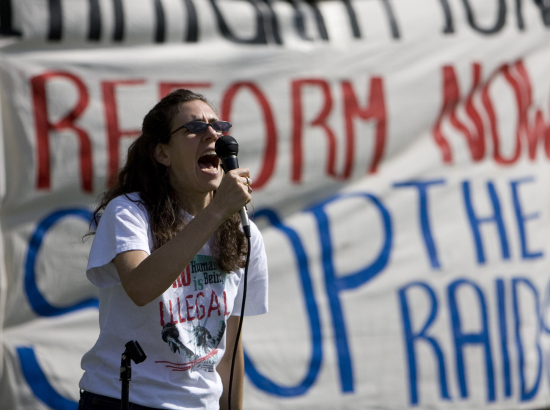 Gabriela C. Flora with the Comite de Servicio de los Amigos Americanos chants for an end to the raids conducted by Immigration and Customs Enforcement agents during a rally at Lincoln Park before the start of a march through downtown Denver