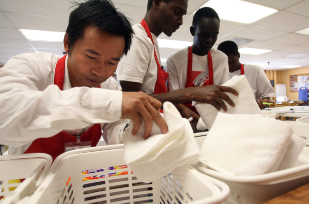 (from left) 34 year-old Thaw Dah Win from Myanmar, Cire Wane (cq) from Mauritania, and Bol Abiar (cq) from Sudan, follow directions written in English, as to how to re-stock a hotel room with sheets and towels
