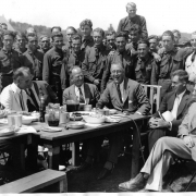 Seated at the head of a mess table in Camp Fechner at Big Meadows, Virginia, one of the five Civilian Conservation Corps camps he visited on August 12, President Roosevelt partook of the camp food, and thoroughly enjoyed the experience.