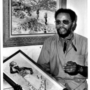 Bob Ragland with paintings done in Jamaica, 1974