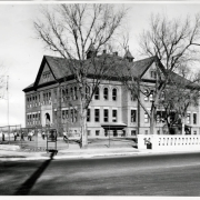 Exterior photograph of Swansea school during recess in Denver, Colorado.  Several students play in the yard outside of the school.