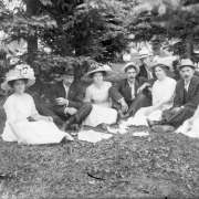 Outdoor portrait of men and women in a Denver, Colorado, park; costume includes large hats with flowers.