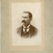 Studio portrait of Colorado State Senator (Las Animas County) Casimiro Barela. He wears a vest and jacket, a tie and stickpin and an upright wing collar. He has a full, bushy mustache and his dark hair has a cowlick and is parted on the side.