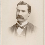Studio portrait of Colorado State Senator (Las Animas County) Casimiro Barela. He wears a vest and jacket, a bow tie and an upright collar. He has a full, waxed mustache and his dark hair has a cowlick and is parted on the side.