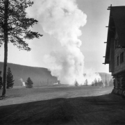 View along the side of rustic 1904 Old Faithful Inn over a steaming Upper Geyser Basin, Yellowstone National Park, Wyoming.
