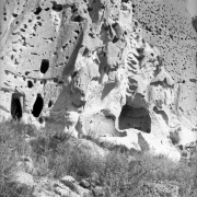 Volcanic tuff cliffs with natural caves enlarged to create living and ceremonial spaces by ancestral Pueblo Indians, Frijoles Canyon, Bandelier National Monument, New Mexico.