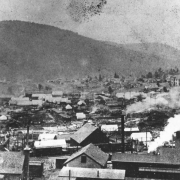 Cripple Creek, Colorado, after first fire on April 25, 1896; possibly view southwest taken from hillside near Midland Terminal Station; possibly Myers Avenue area; many canvas tents amidst debris remain from destructive fire; residences and houses are on distant opposite hillside.