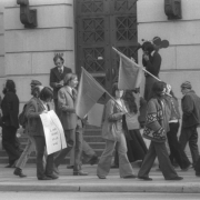 United Farm Workers of America (UFW) supporters picket the Denver City and County building in Denver, Colorado. The picketers protest Judge Robert Cummins' decision to jail UFW coordinator Jerry Ryan for refusing to remove his "Boycott Gallo" button at the beginning of his trial for a prior arrest for picketing. One picket carries a sign with a skull and crossbones that reads: "Cummins drinks Gallo Wine."