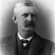 Studio portrait of G. G. Russell of Palmer Lake (El Paso County), Colorado. He wears a suit, bow tie and has a mustache.