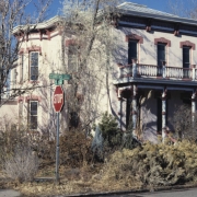 View of the Mannat House (c. 1881) at 2905 Curtis Street in the Five Points neighborhood of Denver, Colorado. This two-story Italianate residence is part of the Curtis Park-Champa Street Historic District. Built for Irving Mannat, a grocer, this brick house has a symmetrical facade, truncated hipped roof, bracketed cornice, lintels, a covered porch, a balustrade and bays.