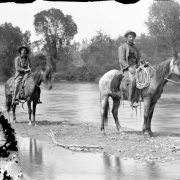 Men on horseback pose on a sandbar in the South Platte River in Denver, Colorado.