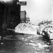 View of Blake Street in Denver, Colorado; shows snow piles and a sign: "Dillon Iron Works."