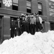 Fire fighters stand on snow bank in Denver, Colorado; Laurence E. Burns, 4th from left.