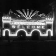 Night view of the illumintated archway on Champa Street and Fourteenth, for the Knights Templar 32nd Triennial Conclave, Denver, Colorado. "Electric sunset and Mt. (Mount) of the Holy Cross. Over 60,000 candle power required to illuminate This electric painting. Rays of the sun  and lighting effects on the mountain peaks are obtained from twelve search  lights."