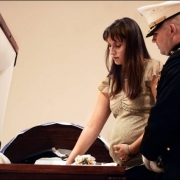 Major Steve Beck takes Katherine Cathey's hand and pressed it down on her husband's uniform.