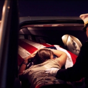 Katherine Cathey falls onto the flag covering his husband's casket.