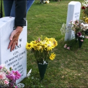 Lori DeMille touches the headstone of fallen Marine Lance Corporal Kyle Burns.