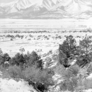 View of fields, snow, and mountains, possibly in Colorado.