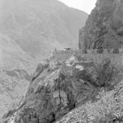 View of the Million Dollar Highway (State Highway 550), Ouray or San Juan County, Colorado; shows road grade, stone guardrails, a car, and a man.