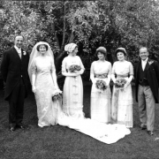Portrait of a wedding group, in Denver, Colorado. The women hold flower bouquets, the bride wears a long train with her dress.