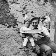 Harry Rhoads holds a piece of watermelon with his daughter Mary Elizabeth (Mitzi) at a gathering in Colorado.