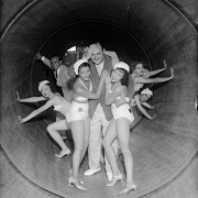 A man poses with women dancers in matching costumes and shoes inside a revolving tube ride at Lakeside Amusement Park in Denver, Colorado.