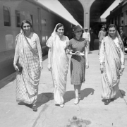 Four Indian women walk through Union Station in Denver, Colorado. Three of the women wear saris and one is dressed in a dress and hat.