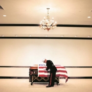 Major Steve Beck folds back the flag while preparing to open James Cathey's casket.