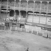 A small group of people are gathered in a bullfight arena.