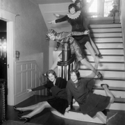 Interior view house shows women posing on a staircase in possibly Denver, Colorado.