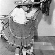Caroline Garcia teaches a young Dorothy Ramirez the step of a Mexican dance at the El Salvador Baptist Church in Denver, Colorado. Dorothy Ramirez wears a traditional Mexican dress and sombrero.